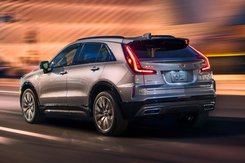 Rear View of the 2025 Cadillac XT4 Driving Fast Through the City at Night